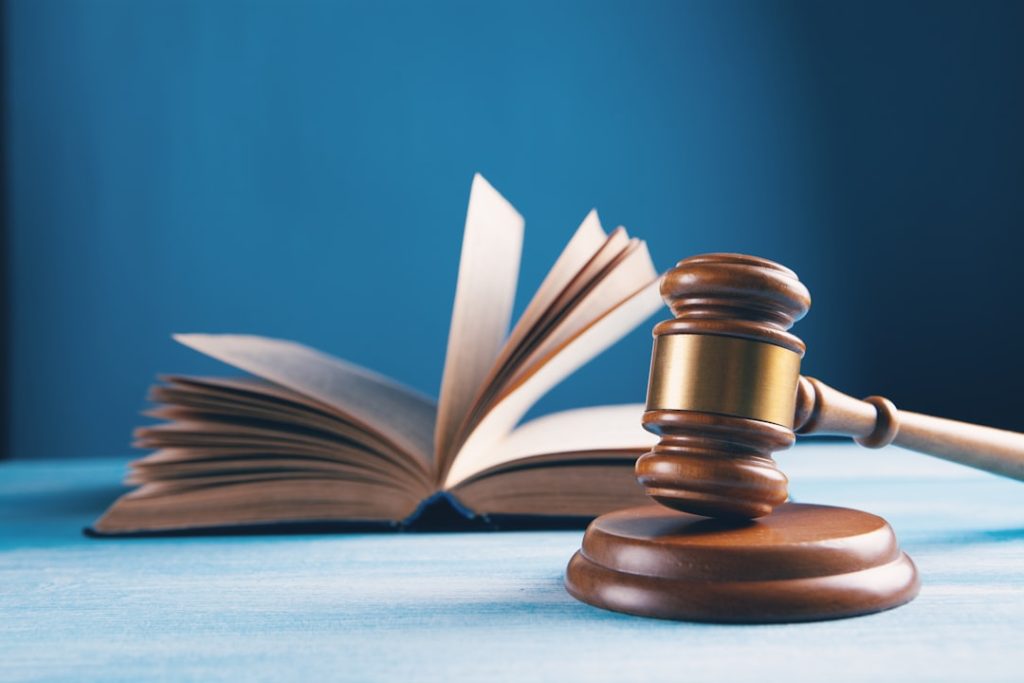 A gavel placed next to an open law book, symbolizing legal concepts.