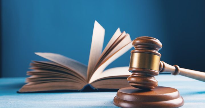 A gavel placed next to an open law book, symbolizing legal concepts.
